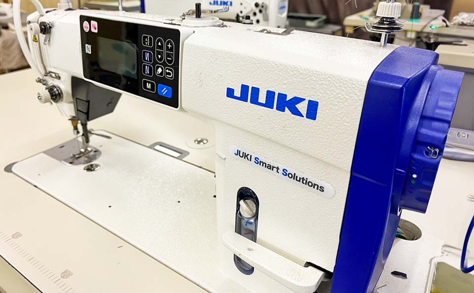 JUKIと書かれたミシン。JUKIはおそらくミシンの製造メーカーまたはブランドの名前であり、縫製には欠かせない機械となっています。